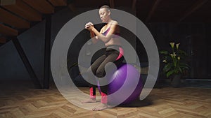 Fit female doing basic bounce exercise on fitball