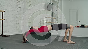 Fit female doing glute bridge exercise with resistance band