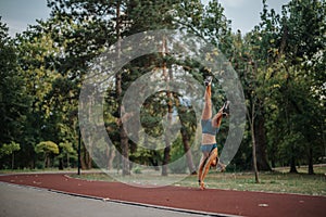 Fit female perform 360-degree flips and cartwheels during evening training in nature's park. Her athleticism and