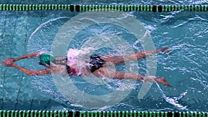 Fit female swimmer doing the breast stroke in the swimming pool