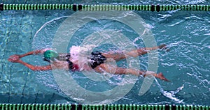 Fit female swimmer doing the breast stroke in the swimming pool