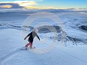 Fit female tourist snowboards the ungroomed slopes near a ski resort in Slovenia photo