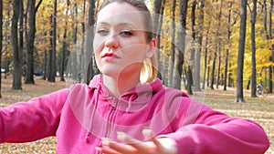 Fit female warms up outside in autumn park