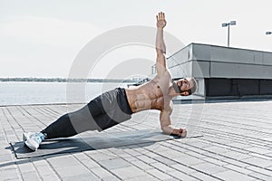 Fit fitness man doing fitness exercises outdoors at city