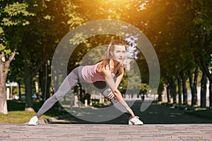 Fit fitness woman doing stretching exercises outdoors at park