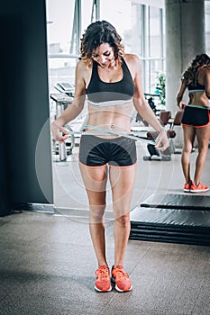 Fit fitness woman measuring her waistline with measure tape