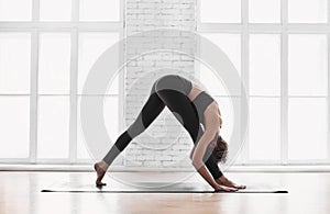Fit girl doing exercises, practicing yoga in class. Young woman meditating at home. Training, harmony, balance, meditation concept