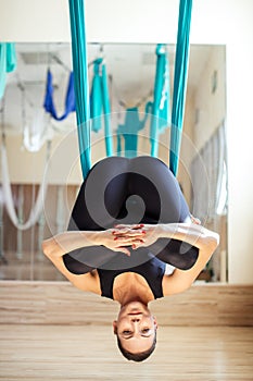 Fit girl in funny pose of antigravity yoga