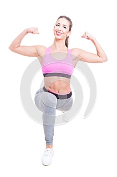 Fit girl posing in lunge position showing biceps