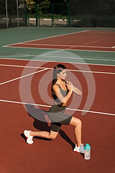 Fit girl is training lunges exercises outdoor. Active young woman does workout outside.