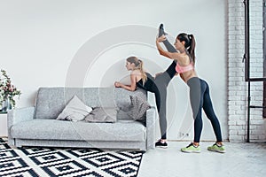 Fit girls preparing legs workout. Leg stretching exercise fitness woman doing warm-up, hamstring muscles stretch
