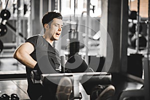 Fit handsome caucasian man sit up on machine in sportswear. Young man sit up exercise to strengthen