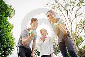Fit happy people working out outdoor. Portrait Family Asian parent and child daughter exercising together on a yoga mat at home