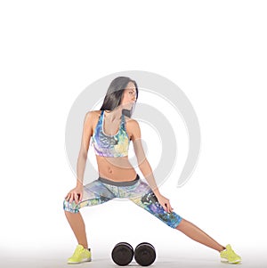 Fit healthy woman exercising, sitting at floor , getting ready to lift weight