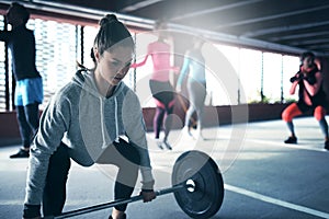 Fit healthy woman lifting a weight barbell