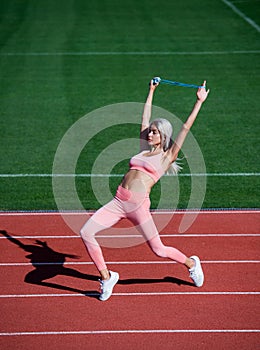 fit lady in fitness wear on stadium with skipping rope on sport workout, activity