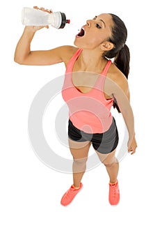 Fit latin sport woman in fitness clothes drinking water tired during training workout