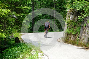 Fit man on active vacation in the Julian Alps goes cycling up a scenic route.