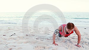 Fit man doing push ups on the beach