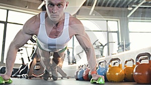 Fit man doing push ups from the floor at gym