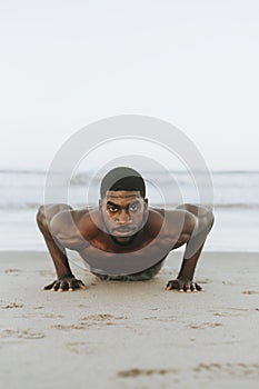 Fit man doing pushups in the sand