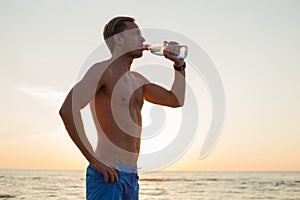 Fit man drinking water after workout