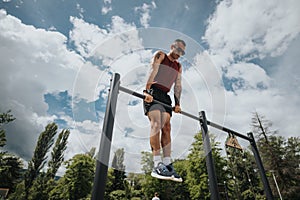 Fit man exercising in urban park under sunny skies, showcasing outdoor fitness lifestyle