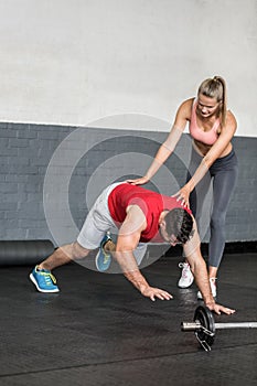 Fit man going plank exercises with trainer