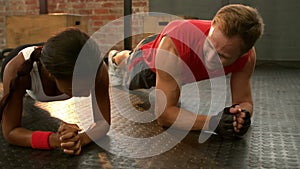 Fit man going plank exercises with trainer