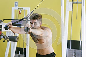 Fit man on lat pull down machine at the health club. Work out on Pull down Weight Machine