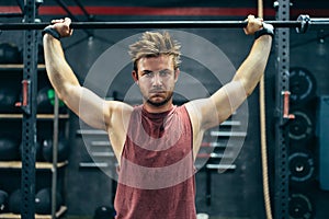 Fit man lifting a barbell in a gym