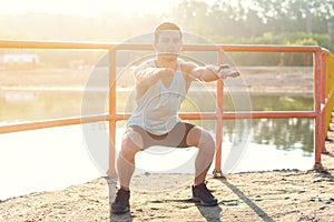 Fit man working out glutes with bodyweight workout doing squat exercises.