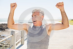 Fit mature man cheering on the pier