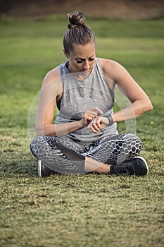 Fit middle aged woman checking her watch after a workout