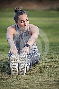 Fit middle aged woman stretching and breathing after a workout