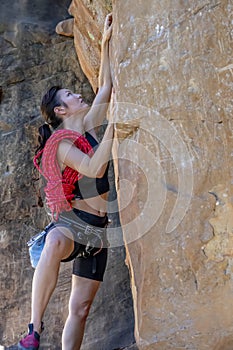 A Fit Mixed Race Female Athlete Rock Climbs In The Pacific Northwest