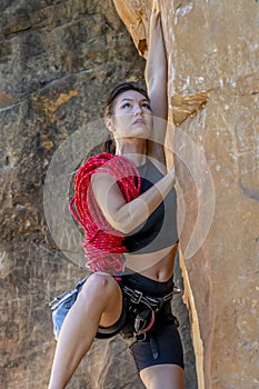 A Fit Mixed Race Female Athlete Rock Climbs In The Pacific Northwest