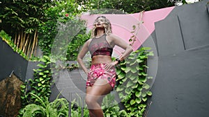 Fit multiethnic woman stretches in outdoor jungle gym. Biethnic female preps for fitness regimen, exotic greenery