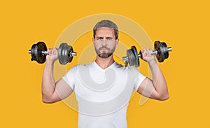 fit muscular fitness guy with barbell. muscular fitness guy training with barbell isolated on yellow.