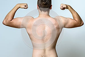 Fit muscular young man flexing his muscles