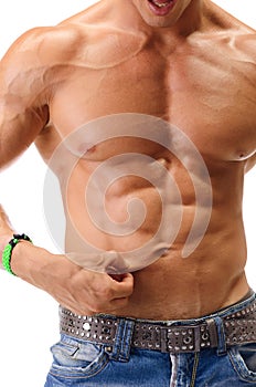 Fit muscular young man pinching his belly skin