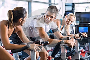 Fit people cycling at gym