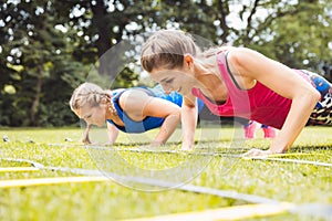 Fit people doing push-ups at the park