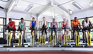 Fit people exercising on exercise bike in fitness center