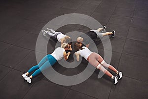 Fit people planking together on the floor of a gym