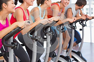 Fit people working out at spinning class