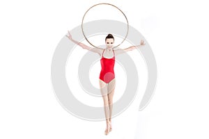 Fit rhythmic gymnast holding hoop on shoulders