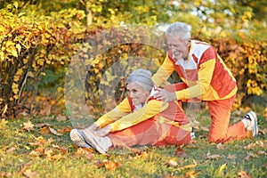 Fit senior couple exercising in autumn park