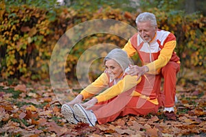 Fit senior couple exercising in autumn park