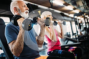 Fit senior sporty couple working out together at gym